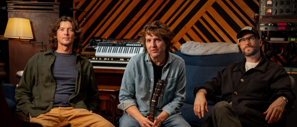 Image of band 'The Milk Carton Kids' sitting in their recording studio, on a couch.