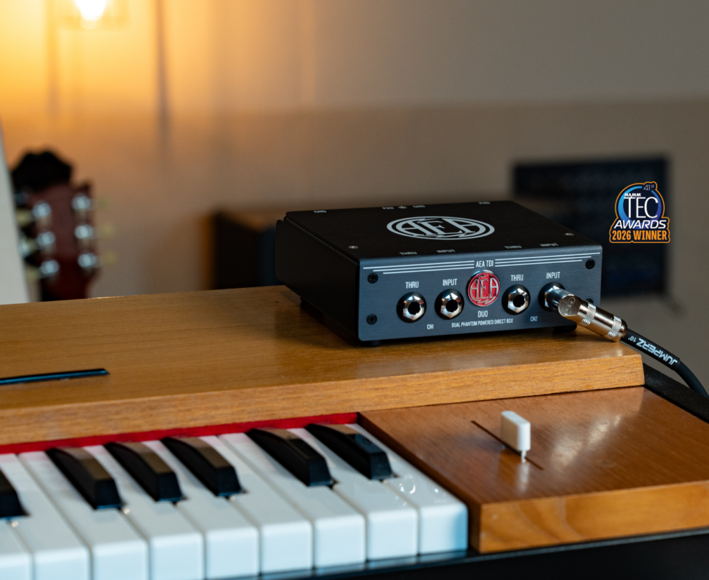 TDI Duo direct box is resting on a piano, a badge in the corner reads 'NAMM TEC Awards 2026 Winner'